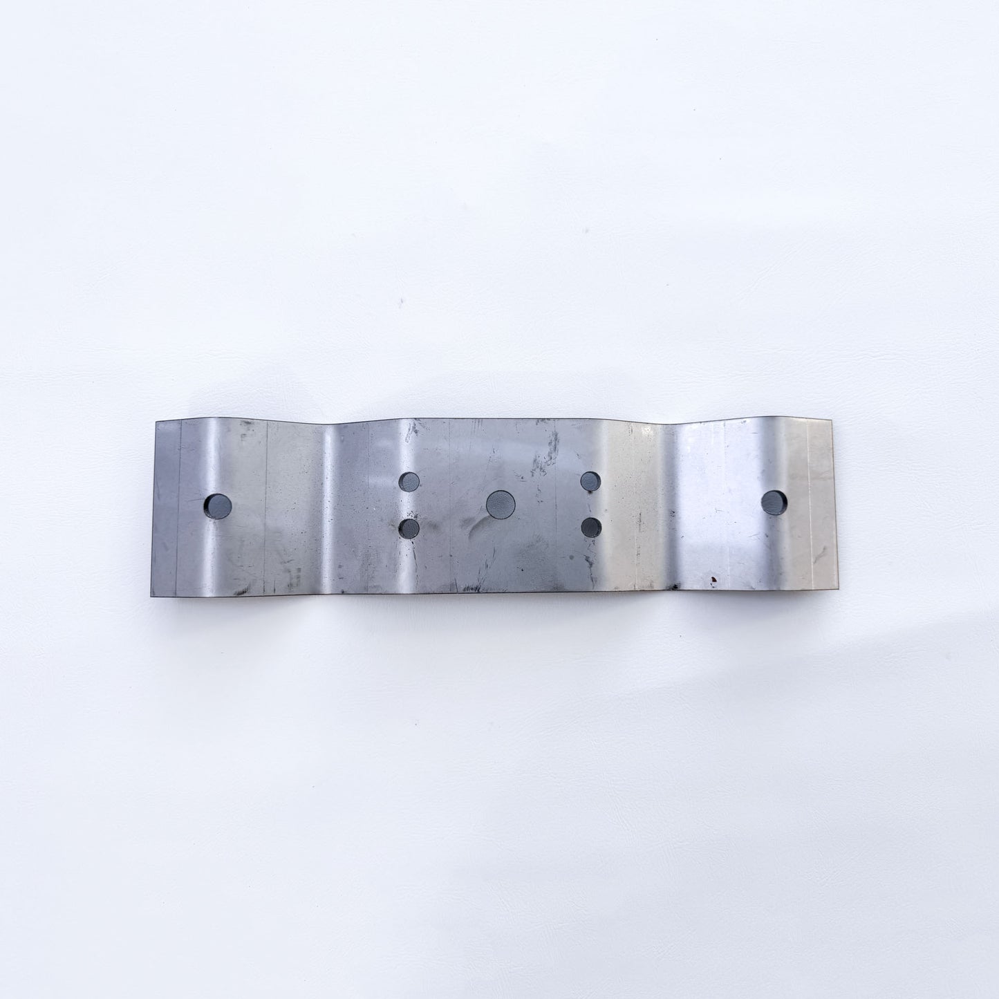 Top view of galvanised Trimdeck roof bracket showing fixing hole pattern