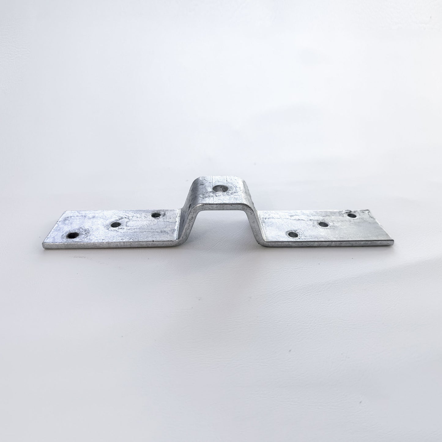 Top view of stainless steel corrugated roof bracket showing fixing hole pattern