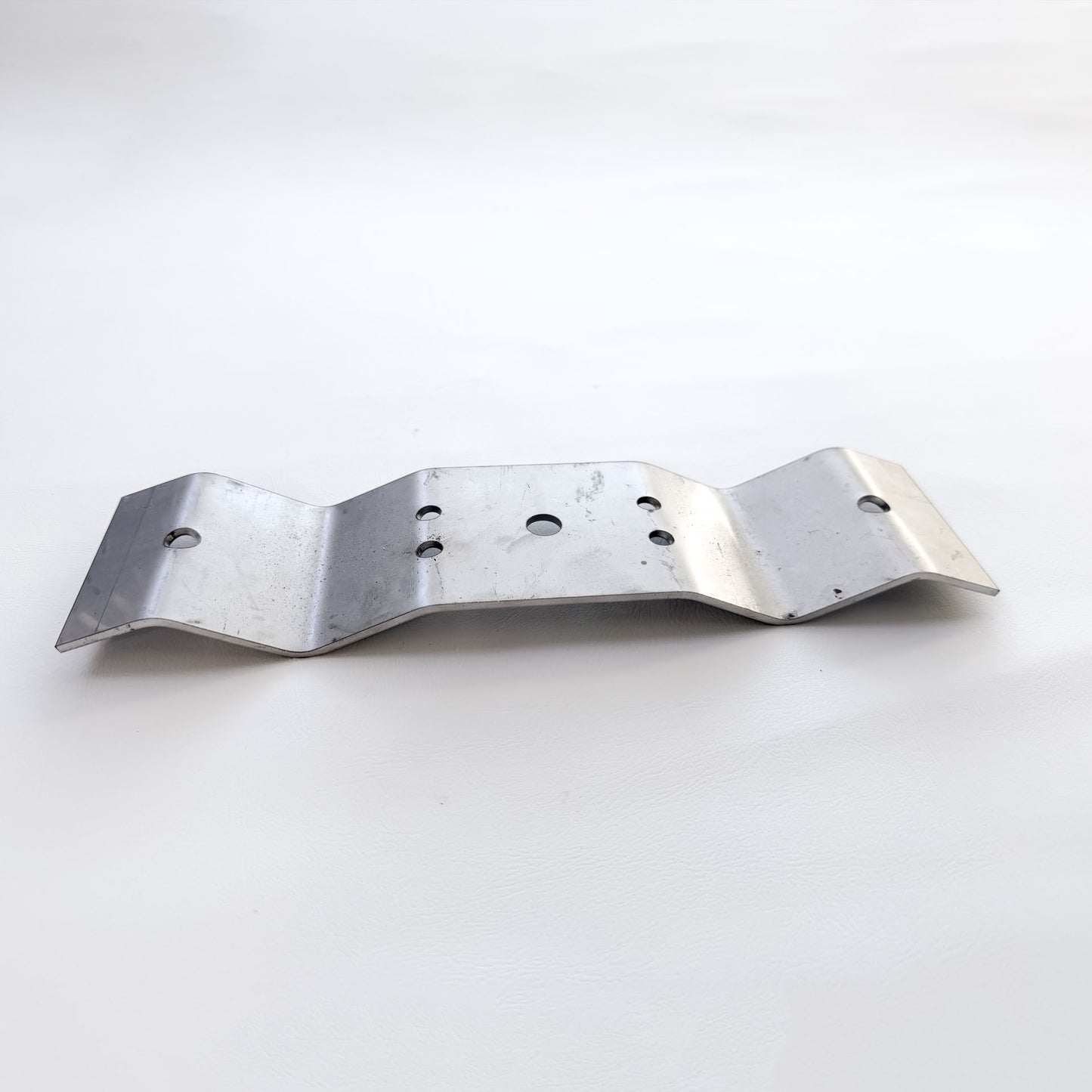 Galvanised Trimdeck roof bracket with fixing holes and ribbed profile