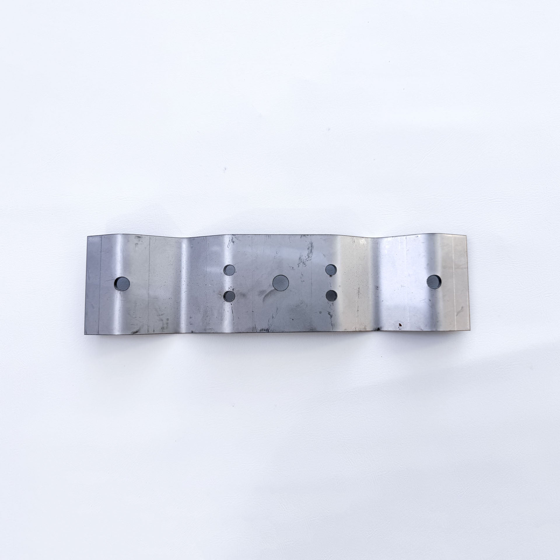 Top view of galvanised Trimdeck roof bracket showing fixing hole pattern